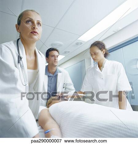 Stock Photo - Medical team pushing patient on gurney. Fotosearch