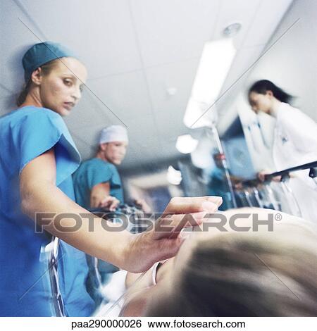Medical team pushing patient on gurney View Large Photo Image Stock Photograph - Medical team pushing patient on gurney . Fotosearch