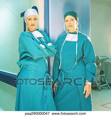 Two female doctors in operating gowns, leaning against doorframe View Large Photo Image Stock Photo - Two female doctors in operating gowns, leaning against doorframe. Fotosearch