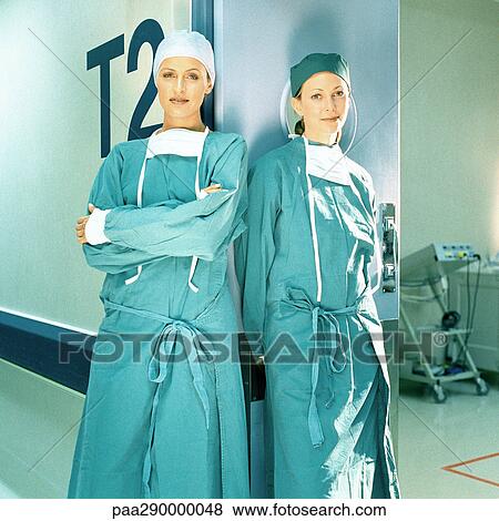 Two female doctors in operating gowns, leaning against doorframe View Large Photo Image Stock Photo - Two female doctors in operating gowns, leaning against doorframe. Fotosearch