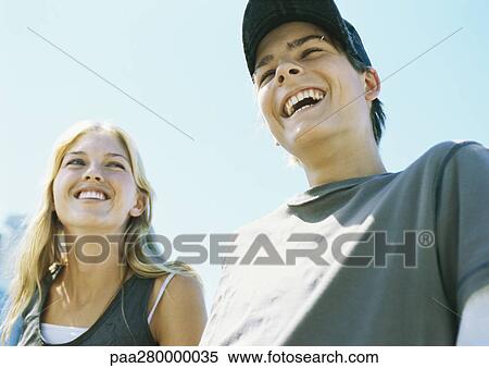 Teenage boy and young woman smiling, low angle view View Large Photo Image Stock Photography - Teenage boy and young woman smiling, low angle view. Fotosearch