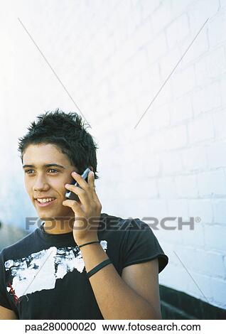 Stock Image - Teenage boy using cell phone. Fotosearch