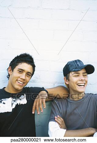 Two teenage boys leaning against brick wall, portrait View Large Photo Image Stock Image - Two teenage boys leaning against brick wall, portrait. Fotosearch