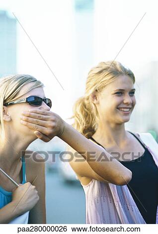 Two teenage girls, one covering the other's mouth View Large Photo Image Stock Photograph - Two teenage girls, one covering the other's mouth. Fotosearch