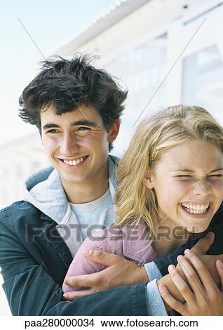 Young couple embracing and laughing View Large Photo Image Picture - Young couple embracing and laughing. Fotosearch