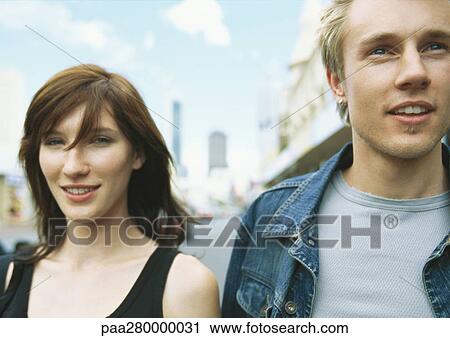 Stock Image - Young couple in city setting, portrait. Fotosearch