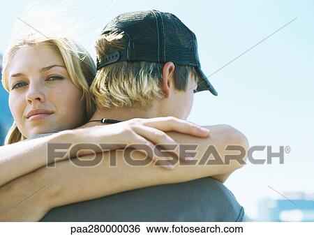 Young woman hugging teenage boy, looking at camera View Large Photo Image Stock Photograph - Young woman hugging teenage boy, looking at camera. Fotosearch