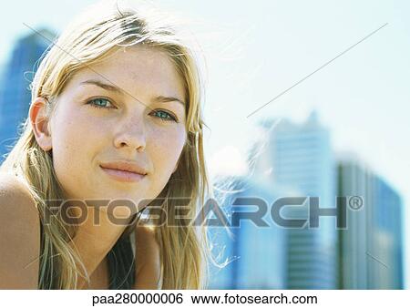 Stock Photograph - Young woman, looking at camera, portrait. Fotosearch