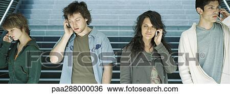 Group of young people using cell phones View Large Photo Image Stock Photograph - Group of young people using cell phones. Fotosearch