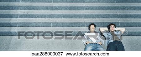 Two young men lying with heads on steps View Large Photo Image Stock Photo - Two young men lying with heads on steps. Fotosearch