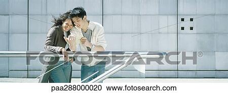 Young couple leaning against rail View Large Photo Image Stock Image - Young couple leaning against rail. Fotosearch
