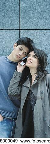 Young couple listening to cell phone together View Large Photo Image Stock Photo - Young couple listening to cell phone together. Fotosearch