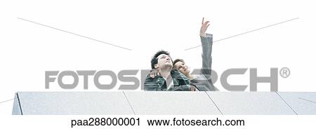 Young couple looking up, low angle view View Large Photo Image Stock Image - Young couple looking up, low angle view. Fotosearch
