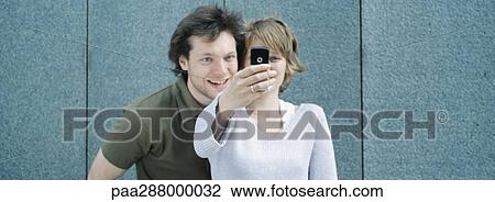 Young couple taking photo with camera phone View Large Photo Image Stock Image - Young couple taking photo with camera phone. Fotosearch