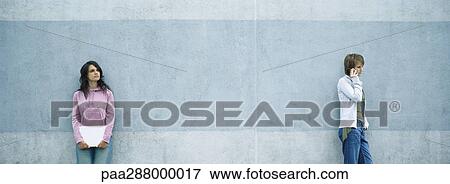 Young man and woman standing apart View Large Photo Image Stock Photo - Young man and woman standing apart. Fotosearch