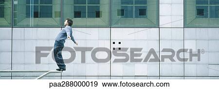 Young man standing on rail View Large Photo Image Stock Photo - Young man standing on rail. Fotosearch