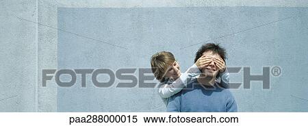 Young woman covering young man's eyes View Large Photo Image Stock Photography - Young woman covering young man's eyes. Fotosearch