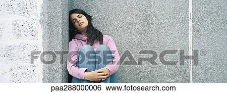 Young woman sitting with eyes closed and knees up View Large Photo Image Stock Photograph - Young woman sitting with eyes closed and knees up. Fotosearch