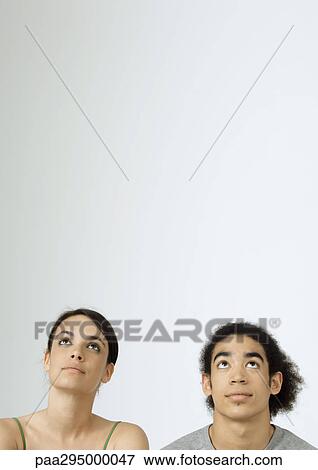 Young couple looking up, portrait View Large Photo Image Stock Photo - Young couple looking up, portrait. Fotosearch