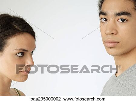 Stock Image - Young couple, woman looking at man, close-up. Fotosearch