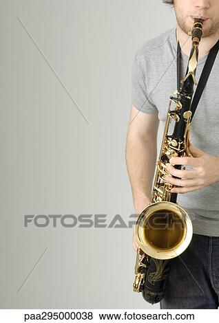 Young man playing saxophone, partial view View Large Photo Image Stock Photo - Young man playing saxophone, partial view. Fotosearch