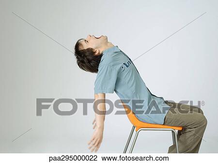 Young man sitting in chair with head back, screaming View Large Photo Image Stock Image - Young man sitting in chair with head back, screaming. Fotosearch