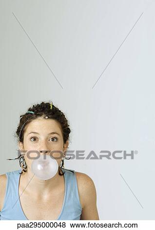 Young woman blowing bubble gum bubble, portrait View Large Photo Image Stock Photo - Young woman blowing bubble gum bubble, portrait. Fotosearch