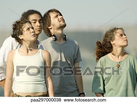 Four young friends standing, looking up at sky View Large Photo Image Stock Photo - Four young friends standing, looking up at sky. Fotosearch