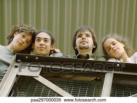 Four young friends standing next to rail, low angle view View Large Photo Image Stock Photography - Four young friends standing next to rail, low angle view. Fotosearch