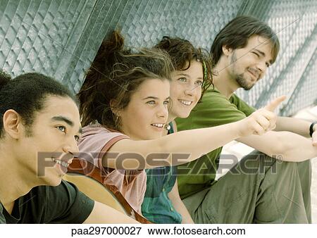 Group of friends, one pointing View Large Photo Image Stock Photo - Group of friends, one pointing. Fotosearch