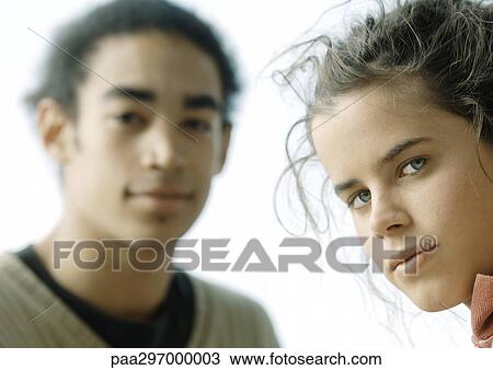 Stock Image - Young couple, looking at camera, close-up. Fotosearch