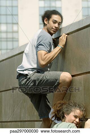 Young man and woman climbing wall View Large Photo Image Stock Image - Young man and woman climbing wall. Fotosearch