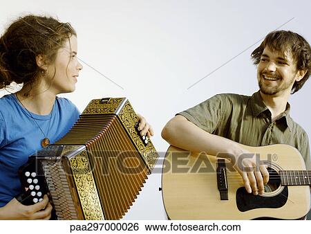 Young man playing guitar, young woman playing accordion View Large Photo Image Stock Photograph - Young man playing guitar, young woman playing accordion. Fotosearch