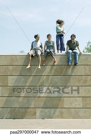 Young people on top of wall View Large Photo Image Stock Photo - Young people on top of wall. Fotosearch