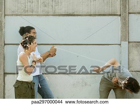 Picture - Young people playing with party string. Fotosearch