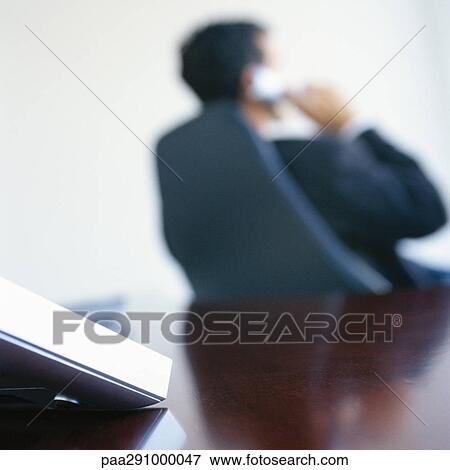 Businessman on phone in office View Large Photo Image Stock Photo - Businessman on phone in office. Fotosearch