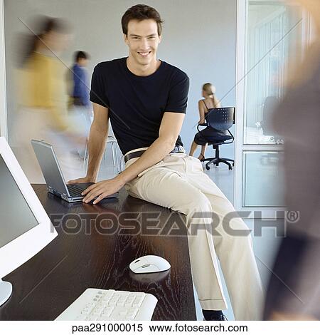 Man Sitting On Edge Of Desk In Busy Office Stock Photography Man Sitting On Edge Of Desk In Busy