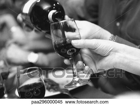 Stock Photography - Man pouring wine for woman. Fotosearch
