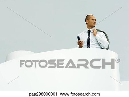Businessman holding cell phone in one hand and jacket over shoulder in the other View Large Photo Image Stock Image - Businessman holding cell phone in one hand and jacket over shoulder in the other. Fotosearch