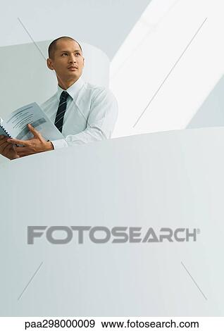 Businessman holding document View Large Photo Image Stock Photo - Businessman holding document. Fotosearch