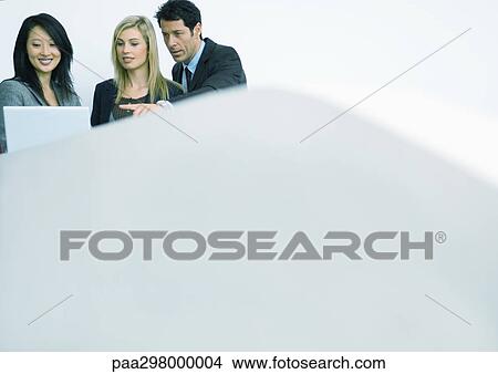 Picture - Businesspeople looking at laptop. Fotosearch