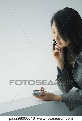 Businesswoman using electronic organizer View Large Photo Image Stock Photograph - Businesswoman using electronic organizer. Fotosearch