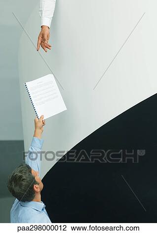 Man holding up document for second person reaching down View Large Photo Image Stock Image - Man holding up document for second person reaching down. Fotosearch