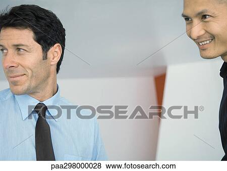 Two businessmen, smiling at looking out of frame View Large Photo Image Stock Photo - Two businessmen, smiling at looking out of frame. Fotosearch