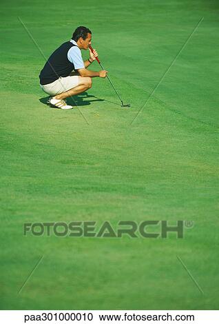 Golfer crouching on green View Large Photo Image Stock Image - Golfer crouching on green. Fotosearch