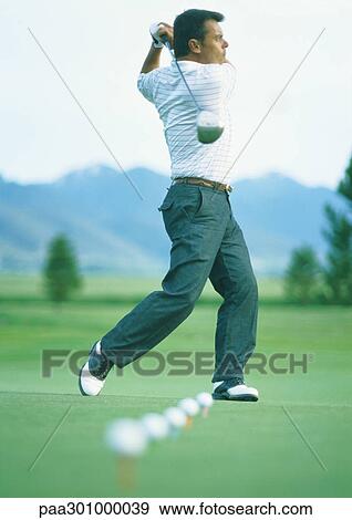 Stock Photo - Golfer practicing on driving range. Fotosearch