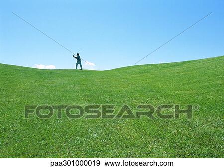 Golfer swinging in distance View Large Photo Image Stock Photo - Golfer swinging in distance. Fotosearch