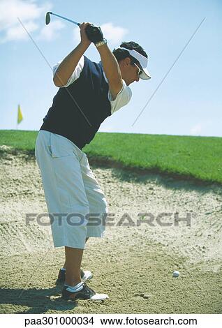 Golfer swinging in sand trap View Large Photo Image Picture - Golfer swinging in sand trap. Fotosearch
