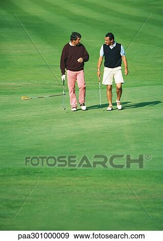Stock Photo - Two golfers walking on golf course. Fotosearch