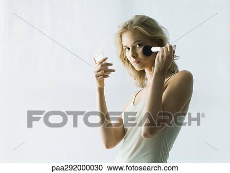 Young woman applying make-up View Large Photo Image Stock Image - Young woman applying make-up. Fotosearch